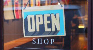 Photo of a storefront door with an 'Open Shop' sign.